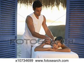 Stock Photograph - serene woman lies 
on a bed being 
given a shoulder 
massage by a male. 
fotosearch - search 
stock photos, 
pictures, images, 
and photo clipart
