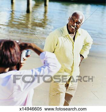 Stock Image - elderly woman 
photographing 
elderly man at 
waters edge. fotosearch 
- search stock 
photos, pictures, 
images, and photo 
clipart