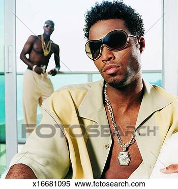 Stock Image - portrait of a 
young man wearing 
sunglasses and 
a necklace with. 
fotosearch - search 
stock photos, 
pictures, images, 
and photo clipart