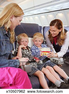 Stock Photo - air stewardess 
offering snack 
to twin boys (3-5) 
smiling. fotosearch 
- search stock 
photos, pictures, 
images, and photo 
clipart