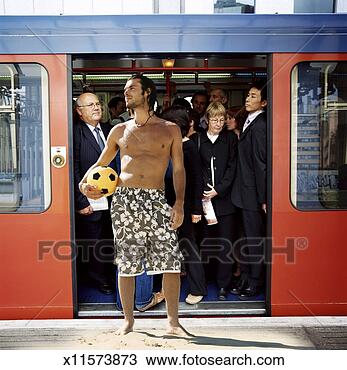 Stock Photo - man standing on 
beach in front 
of open doors 
of busy train. 
fotosearch - search 
stock photos, 
pictures, images, 
and photo clipart