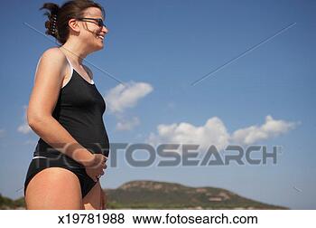 Stock Photo - preganant woman 
wearing swimsuit 
outdoors, smiling, 
profile. fotosearch 
- search stock 
photos, pictures, 
images, and photo 
clipart