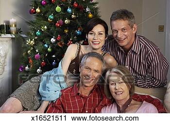 Stock Photography - couple relaxing 
by christmas tree 
with mature couple, 
 smiling. fotosearch 
- search stock 
photos, pictures, 
images, and photo 
clipart