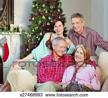 Stock Photo - couple and senior 
couple sitting 
in living room 
by christmas tree. 
fotosearch - search 
stock photos, 
pictures, images, 
and photo clipart