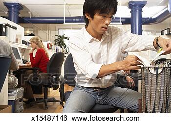 Stock Photo - male office worker 
looking in drop 
file, female worker 
in background. 
fotosearch - search 
stock photos, 
pictures, images, 
and photo clipart