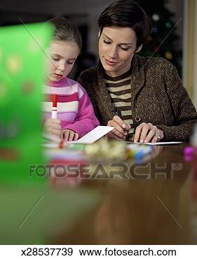Stock Photograph - mother and daughter 
(5-7) writing 
cards, focus on 
mother and daughter. 
fotosearch - search 
stock photos, 
pictures, images, 
and photo clipart