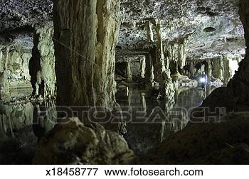 Picture - man with flashlight 
looking into underground 
cave. fotosearch 
- search stock 
photos, pictures, 
images, and photo 
clipart