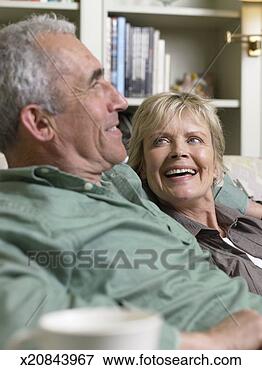 Picture - mature couple 
relaxing on sofa, 
smiling, close-up 
(focus on couple). 
fotosearch - search 
stock photos, 
pictures, images, 
and photo clipart
