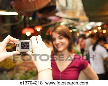 Stock Photo - woman taking photograph 
of friend, focus 
on camera. fotosearch 
- search stock 
photos, pictures, 
images, and photo 
clipart