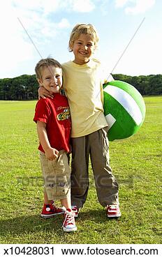 Stock Photography - boy (4-6) holding 
ball with arm 
around brother 
(2-4) in park, 
portrait. fotosearch 
- search stock 
photos, pictures, 
images, and photo 
clipart