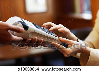 Stock Photo - young woman typing 
pin number into 
portable swipe 
machine, close-up. 
fotosearch - search 
stock photos, 
pictures, images, 
and photo clipart