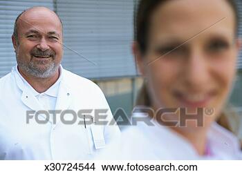 Stock Photo - male and female 
doctor outdoors, 
 focus on male 
doctor,  smiling. 
fotosearch - search 
stock photos, 
pictures, images, 
and photo clipart