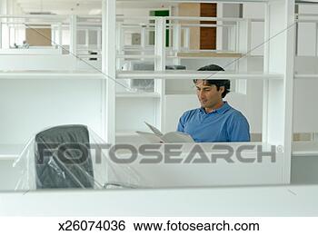 Stock Photo - male office worker 
looking at documents 
in newly finished 
office. fotosearch 
- search stock 
photos, pictures, 
images, and photo 
clipart