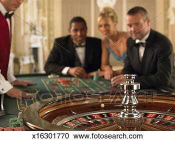 Stock Photography - three gamblers 
at roulette table 
with croupier, 
 focus on roulette. 
fotosearch - search 
stock photos, 
pictures, images, 
and photo clipart