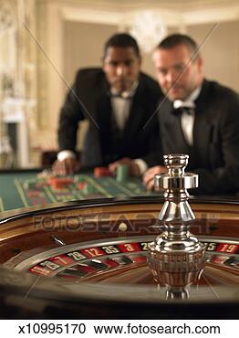 Stock Photography - two male gamblers 
at roulette table, 
focus on roulette 
wheel. fotosearch 
- search stock 
photos, pictures, 
images, and photo 
clipart