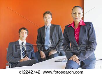 Stock Photo - business woman 
sitting on desk, 
 two business 
men sitting behind. 
fotosearch - search 
stock photos, 
pictures, images, 
and photo clipart