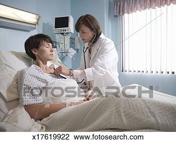 Stock Photo - female doctor 
examining woman 
with stethoscope 
in hospital. fotosearch 
- search stock 
photos, pictures, 
images, and photo 
clipart