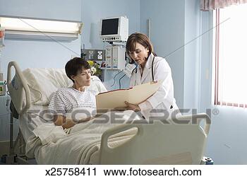 Stock Photography - female doctor 
showing medical 
chart to female 
patient lying 
in. fotosearch 
- search stock 
photos, pictures, 
images, and photo 
clipart