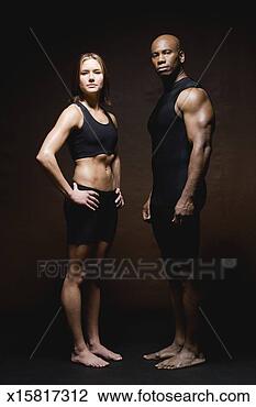 Stock Photo - fitness couple 
in workout clothes 
standing on brown 
background. fotosearch 
- search stock 
photos, pictures, 
images, and photo 
clipart