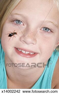 Stock Photo - girl (8-9) with 
insect crawling 
on face, portrait, 
close-up. fotosearch 
- search stock 
photos, pictures, 
images, and photo 
clipart