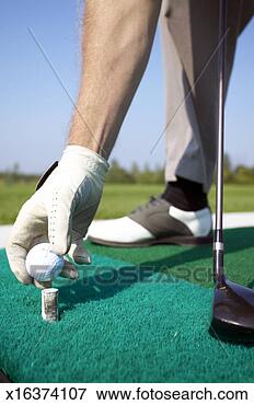 Picture - man wearing golf 
glove putting 
ball on tee, low 
section. fotosearch 
- search stock 
photos, pictures, 
images, and photo 
clipart