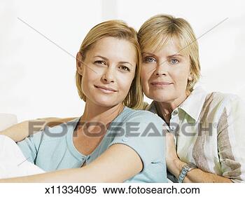 Stock Image - mature mother 
and mid adult 
daughter sitting 
on sofa, portrait. 
fotosearch - search 
stock photos, 
pictures, images, 
and photo clipart