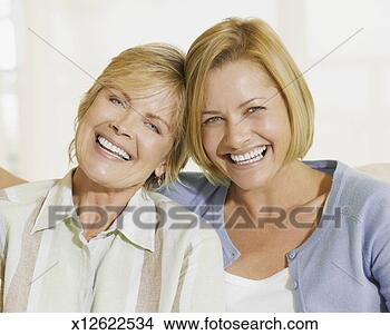 Stock Photo - mature mother 
and mid adult 
daughter laughing, 
 sitting on sofa. 
fotosearch - search 
stock photos, 
pictures, images, 
and photo clipart
