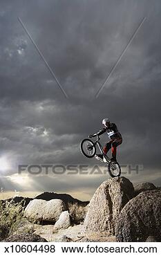 Stock Photo - mountain bike 
rider doing wheely 
on rock. fotosearch 
- search stock 
photos, pictures, 
images, and photo 
clipart