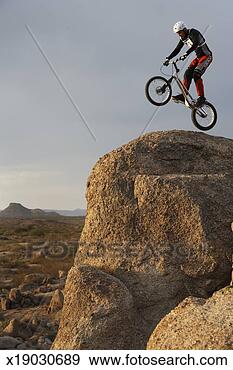 Stock Photograph - mountain bike 
rider doing wheely 
on mountain peak, 
side view. fotosearch 
- search stock 
photos, pictures, 
images, and photo 
clipart