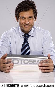 Stock Photograph - portrait of mature 
man with pile 
of notebooks, 
studio shot. fotosearch 
- search stock 
photos, pictures, 
images, and photo 
clipart