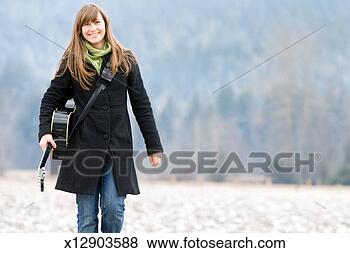 Stock Photo - portrait of mid 
adult woman in 
fields with guitar. 
fotosearch - search 
stock photos, 
pictures, images, 
and photo clipart