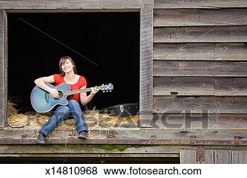 Stock Photo - portrait of woman 
playing acustic 
guitar in barn 
window. fotosearch 
- search stock 
photos, pictures, 
images, and photo 
clipart