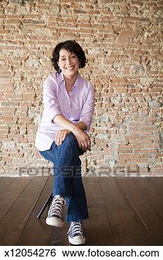 Stock Photo - portrait of woman 
sitting in front 
of brick wall. 
fotosearch - search 
stock photos, 
pictures, images, 
and photo clipart