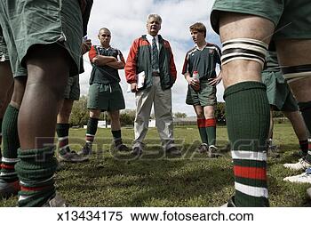 Stock Image - rugby players 
standing around 
coach on lawn, 
low angle view. 
fotosearch - search 
stock photos, 
pictures, images, 
and photo clipart
