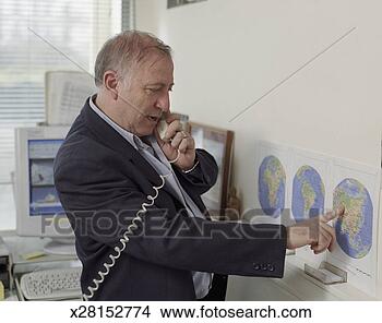 Stock Photo - senior business 
man in office 
talking on phone, 
pointing at map. 
fotosearch - search 
stock photos, 
pictures, images, 
and photo clipart