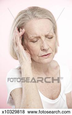 Stock Photo - senior woman with 
hand on temple 
and eyes shut. 
fotosearch - search 
stock photos, 
pictures, images, 
and photo clipart