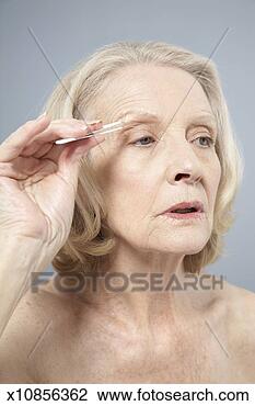 Stock Photo - senior woman tweezing 
eyebrows, close-up. 
fotosearch - search 
stock photos, 
pictures, images, 
and photo clipart