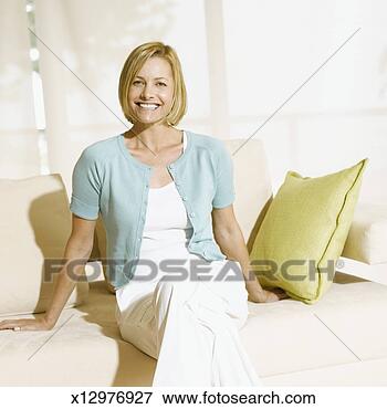 Picture - woman sitting 
on sofa, portrait. 
fotosearch - search 
stock photos, 
pictures, images, 
and photo clipart