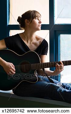 Stock Photo - woman sitting 
on window sill 
playing acustic 
guitar. fotosearch 
- search stock 
photos, pictures, 
images, and photo 
clipart