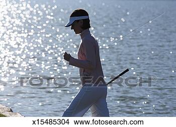 Stock Photo - woman walking 
with golf club, 
pond in background. 
fotosearch - search 
stock photos, 
pictures, images, 
and photo clipart