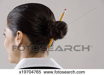 Stock Image - young woman with 
pencil in hair 
bun, rear view. 
fotosearch - search 
stock photos, 
pictures, images, 
and photo clipart