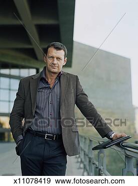 Stock Photograph - man leaning on 
rail with one 
hand in pocket, 
outdoors, portrait. 
fotosearch - search 
stock photos, 
pictures, images, 
and photo clipart