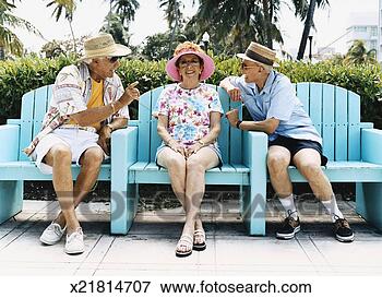 Picture - senior woman sits 
on a patio chair 
between two senior 
men talking to. 
fotosearch - search 
stock photos, 
pictures, images, 
and photo clipart