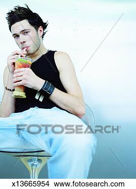 Stock Photo - young man drinking 
fruit drink through 
straws, portrait. 
fotosearch - search 
stock photos, 
pictures, images, 
and photo clipart