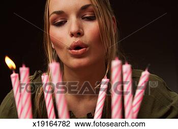 Stock Photo - young woman blowing 
out candles, focus 
on woman. fotosearch 
- search stock 
photos, pictures, 
images, and photo 
clipart