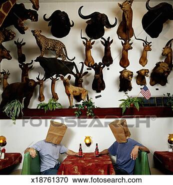 Stock Photography - two men wearing 
brown bags on 
heads at table 
under dead animals. 
fotosearch - search 
stock photos, 
pictures, images, 
and photo clipart