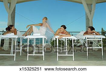 Stock Photography - four women on 
massage tables, 
one laughing wearing 
bridal veil. fotosearch 
- search stock 
photos, pictures, 
images, and photo 
clipart