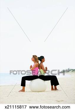 Picture - two women on beach 
sitting back to 
back on fitness 
ball. fotosearch 
- search stock 
photos, pictures, 
images, and photo 
clipart