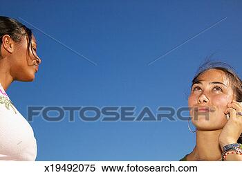 Stock Image - two teenage girls 
(15-17), one girl 
talking on cell 
phone. fotosearch 
- search stock 
photos, pictures, 
images, and photo 
clipart