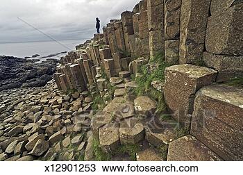 Stock Photo - ireland, antrim 
county, giant's 
causeway, man 
looking out at 
ocean. fotosearch 
- search stock 
photos, pictures, 
images, and photo 
clipart